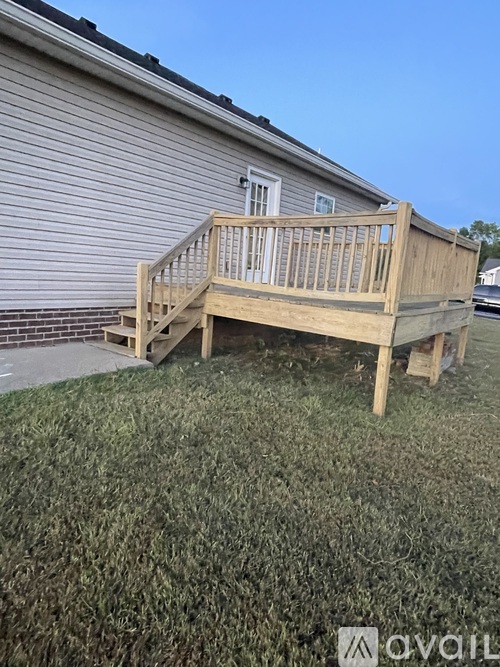 A wooden deck is in front of a house.