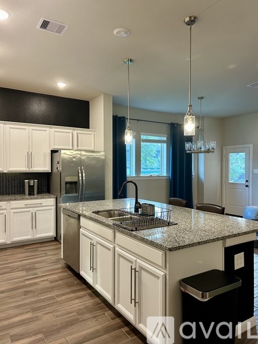 A kitchen with white cabinets and a granite countertop.