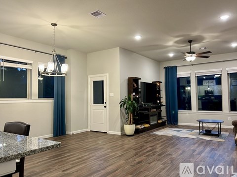 A spacious living room with a marble table and a ceiling fan.