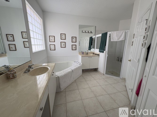 A bathroom with a sink, mirror, and bathtub.