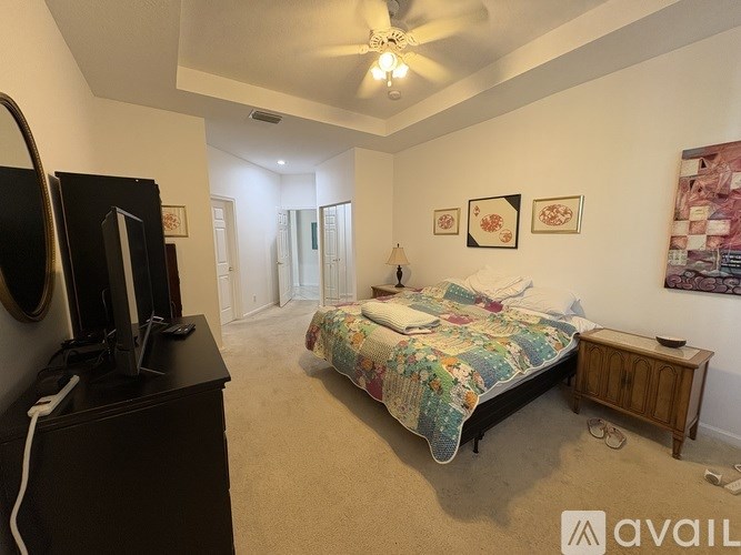 A bedroom with a bed, dresser, and television.