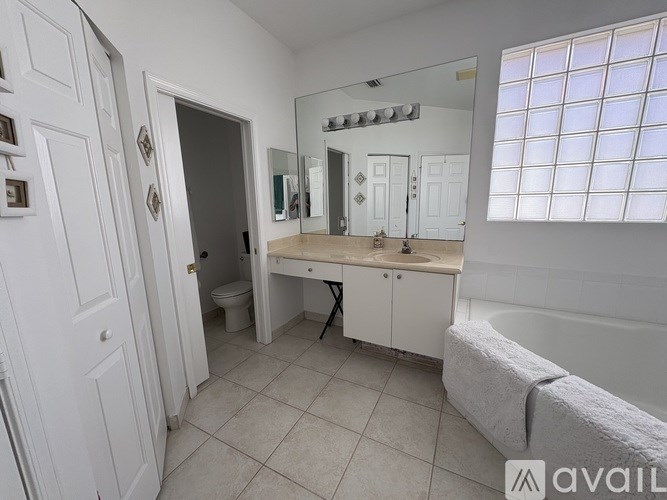 A bathroom with a toilet, sink, and mirror.