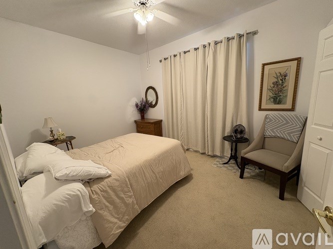 A bedroom with a large bed and a chair.