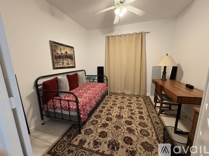 A bedroom with a bed, desk, and chair.