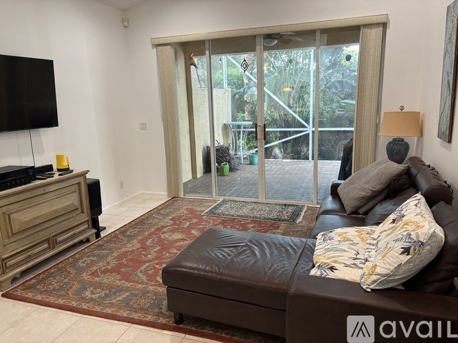 A living room with a brown couch and a flat screen TV.
