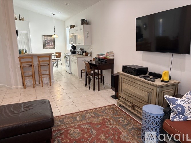 A living room with a television, a sofa, and a rug.