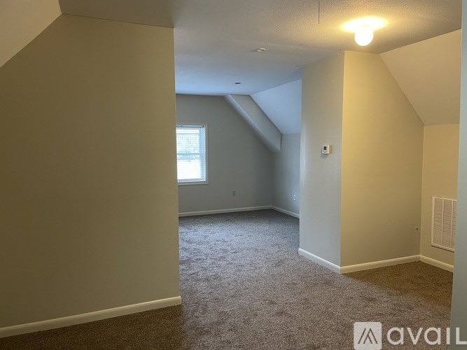 A room with a carpeted floor and a window.