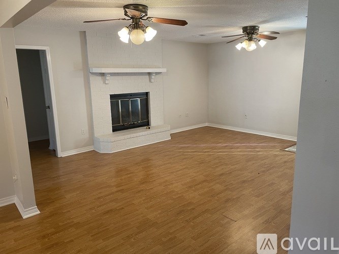 A room with a fireplace and a ceiling fan.
