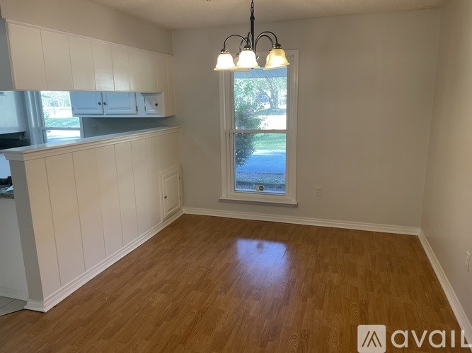 A room with wooden floors and a window overlooking a street.