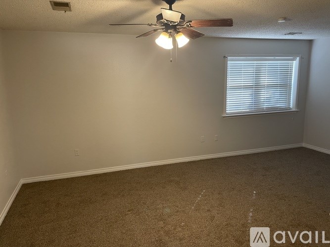 A room with a ceiling fan and a window with blinds.