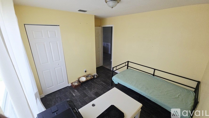 A bedroom with a bed, desk, and chair.