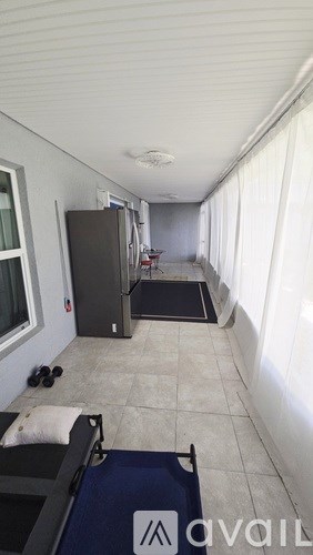 A room with a refrigerator and a mattress on the floor.