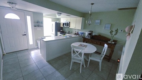 A kitchen with a table and chairs in the middle of the room.