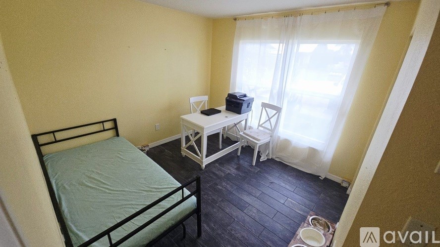 A bedroom with a bed, chair, and table.