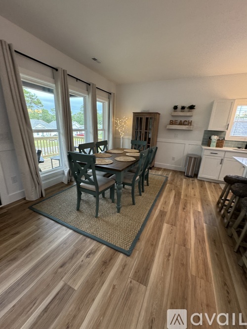 A dining room with a wooden floor and a table set for four.