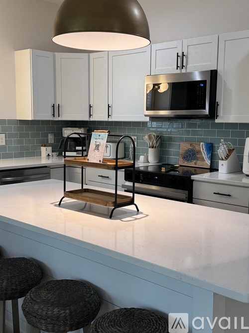 A kitchen with a white counter top and a microwave above it.