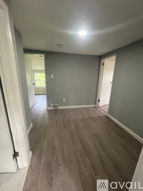 A room with wooden flooring and white walls.