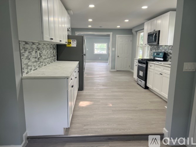 A kitchen with white cabinets and a refrigerator.