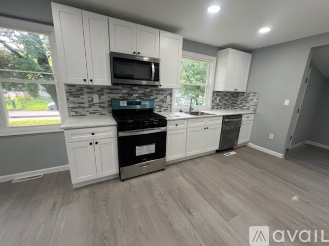 A kitchen with white cabinets and a black stove top oven.