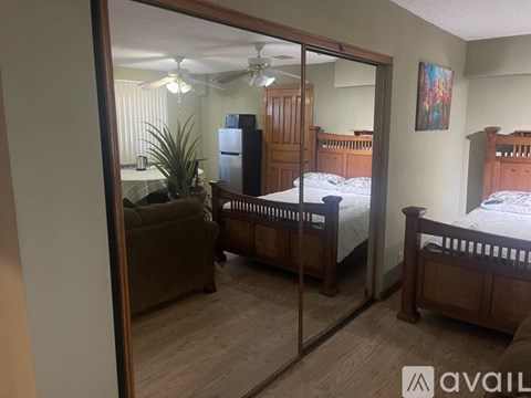 A bedroom with a couch, a bed, and a dresser is shown in the image.