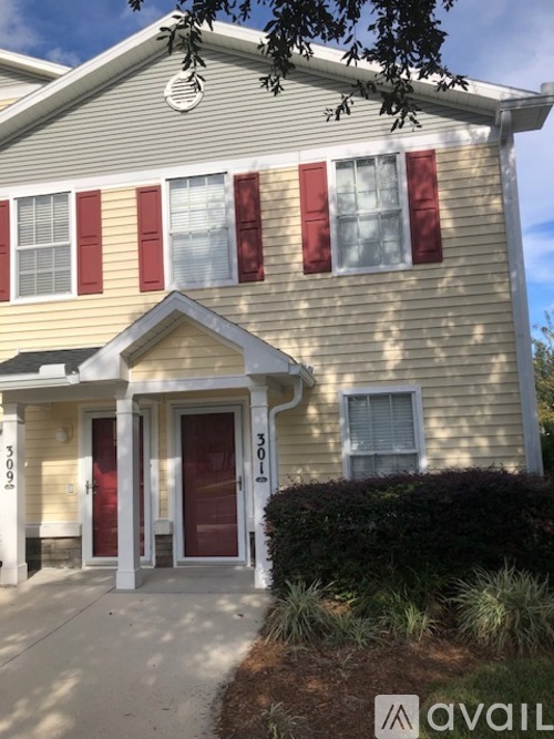 A house with a red door and windows with red shutters.
