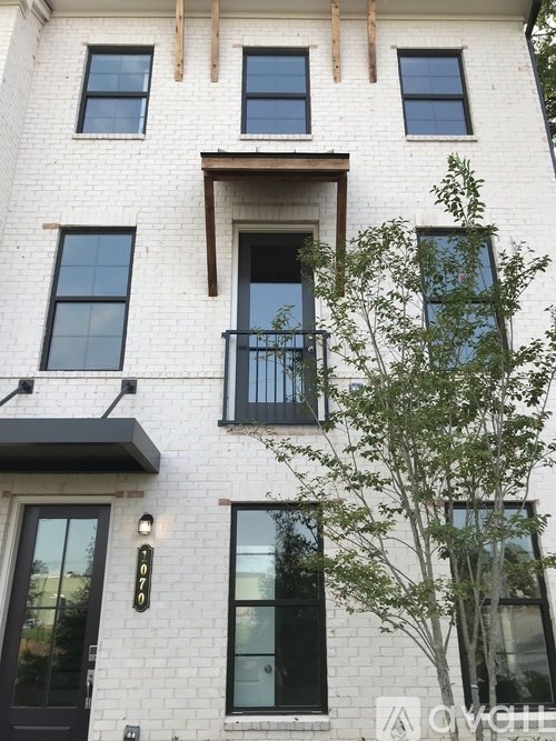 A white building with black windows and a balcony.