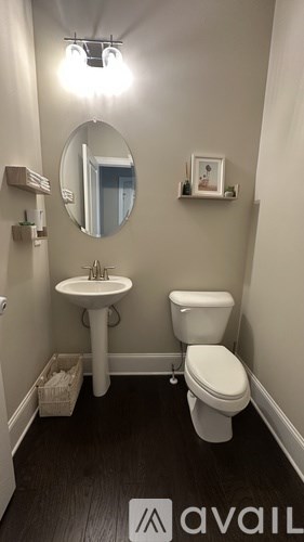 A small bathroom with a toilet, sink, and mirror.