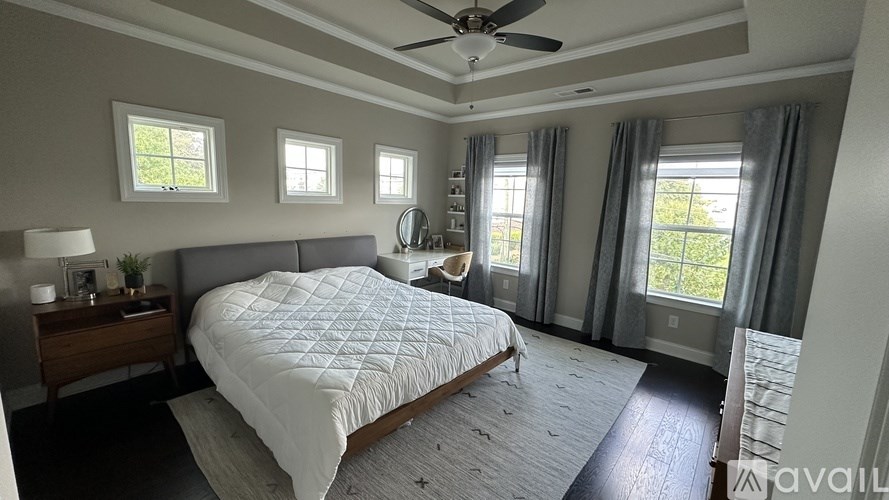 A bedroom with a large bed and a ceiling fan.