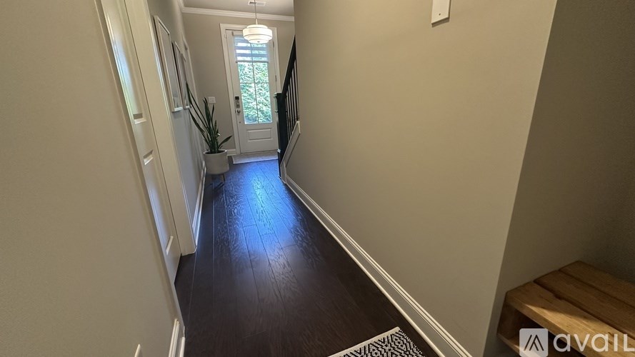 A hallway with a wooden floor and a door at the end.