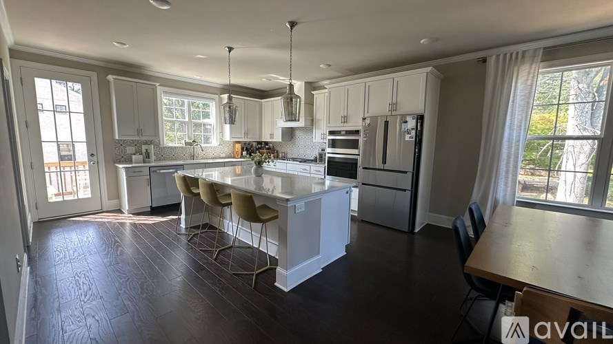 A kitchen with a table and chairs in front of a window.