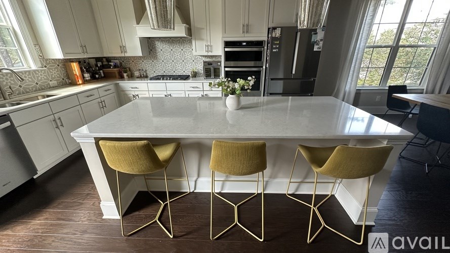 A kitchen with a table and chairs in the foreground.