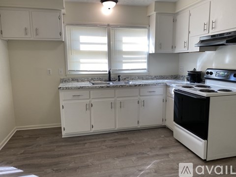 A kitchen with white cabinets and a black stove top oven.