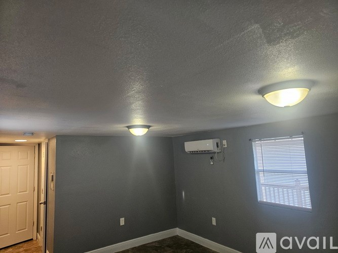 A room with a ceiling fan and a window with blinds.