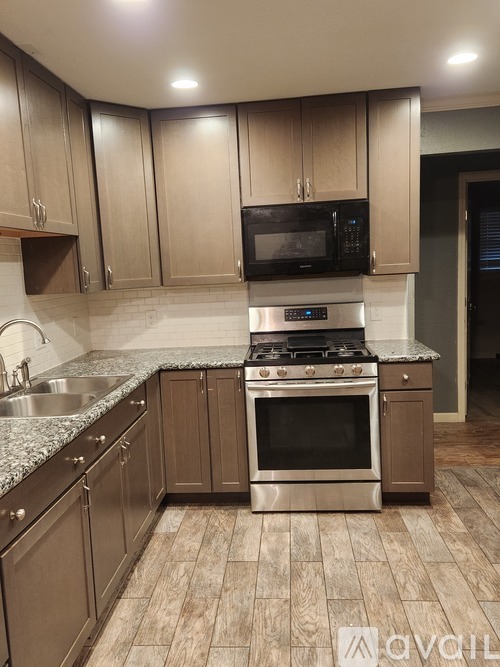 A kitchen with wooden cabinets and a stainless steel stove top oven.