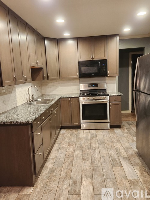 A kitchen with wooden cabinets and a granite countertop.