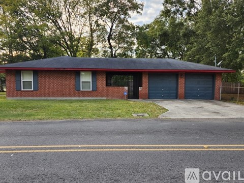 A red brick house with a black roof and a blue garage door.
