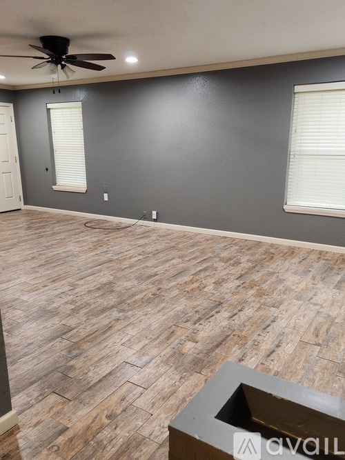 A room with wooden flooring and a ceiling fan.