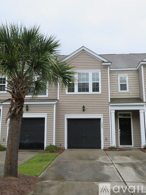 A house with a palm tree in front.