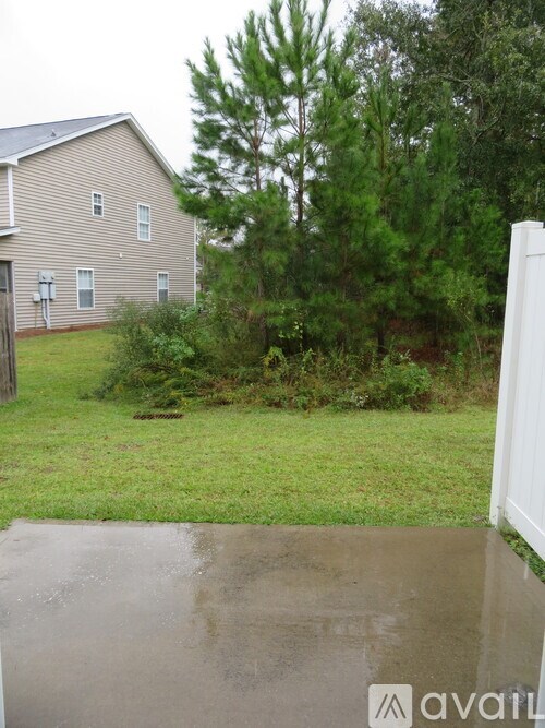 A house with a wet ground in front of it.