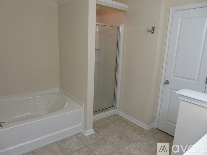 A white bathroom with a tub, shower, and toilet.