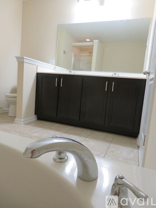 A bathroom with a white tub and a large mirror.