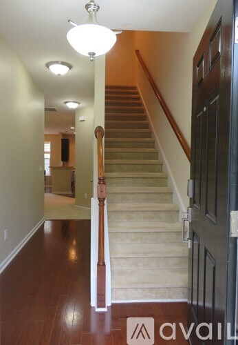 A staircase with a wooden handrail and a light on the ceiling.