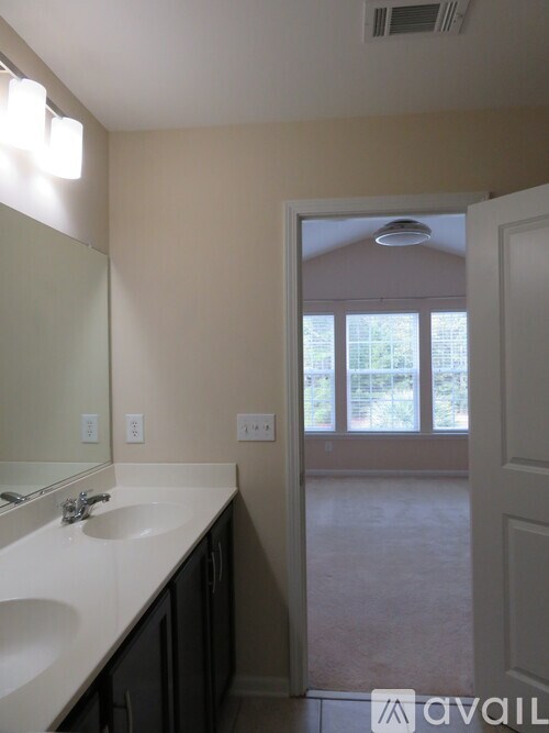 A bathroom with a double sink vanity and a large mirror.