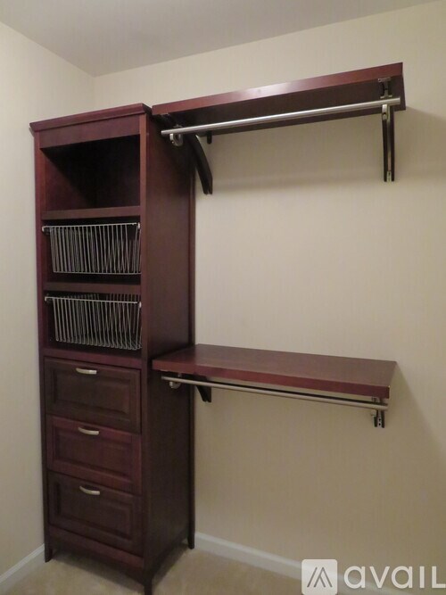 A brown wooden cabinet with a shelf and drawers.