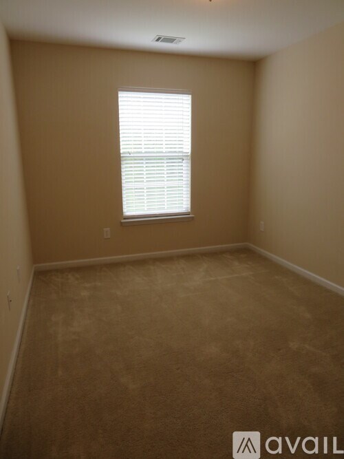 A room with a window and carpeted floor.
