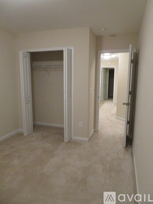 A room with a carpeted floor and a white door.