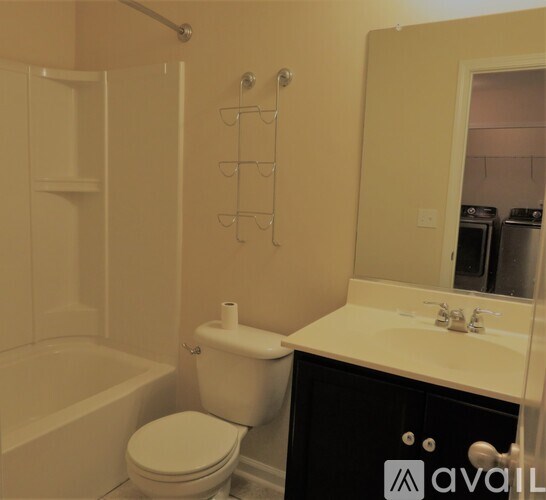 A white toilet sits next to a bathtub in a bathroom.