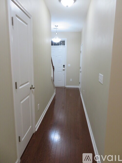 A hallway with wood floors and white doors.