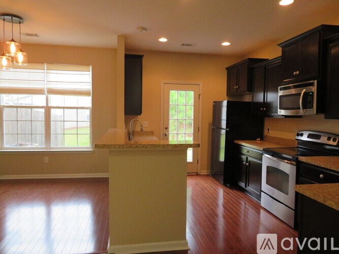 A kitchen with black cabinets and a white island.