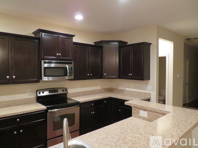 A kitchen with dark wood cabinets and granite countertops.